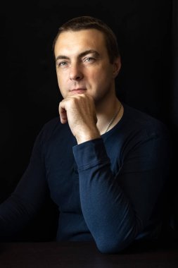 Mavi gömlekli, siyah anahtarlı bir gencin portresi..