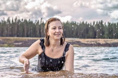 Sudaki genç bir kadının portresi. Gölde yüzmek, su sıçratmak