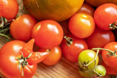 Tahta bir arka planda bitkilerle olgunlaşmış sebzeler. Bahçeden hasat et..