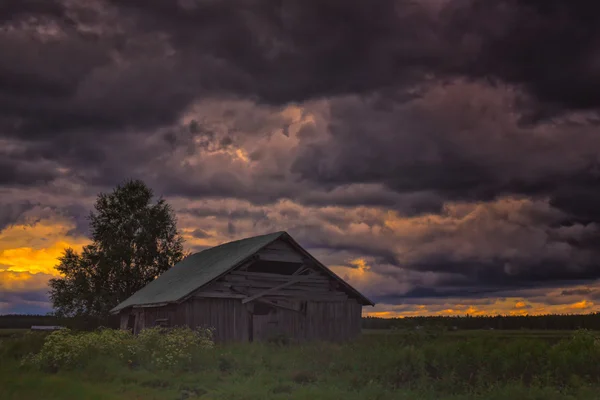 Terk edilmiş Barn House fırtına bulutları altında