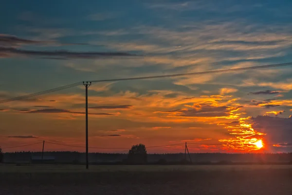 Setter solen ser ut fra skyene – stockfoto