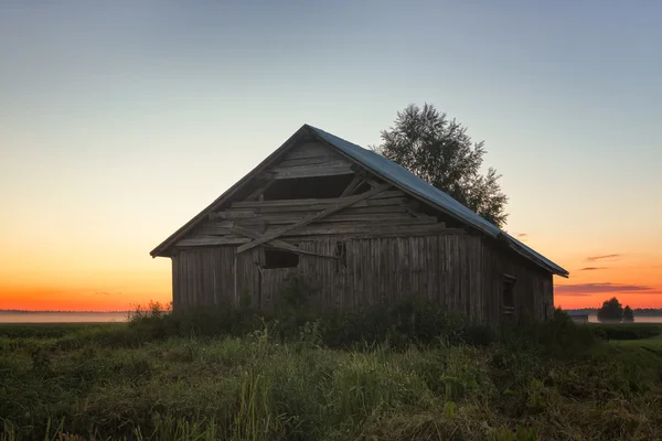 Coucher de soleil derrière une grange et un bouleau — Photo