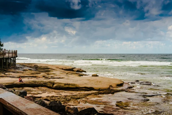 Nő ült a sziklák az óceán — Stock Fotó