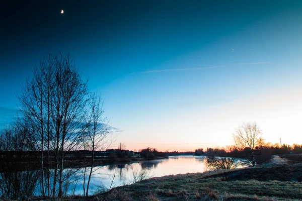 Maan en zonsondergang op de rivier — Stockfoto