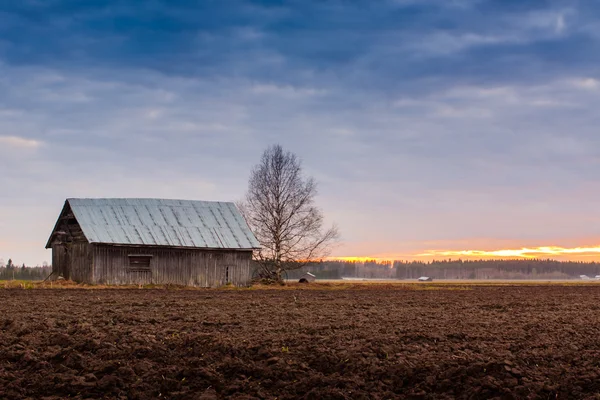 Coucher de soleil et une maison de grange — Photo