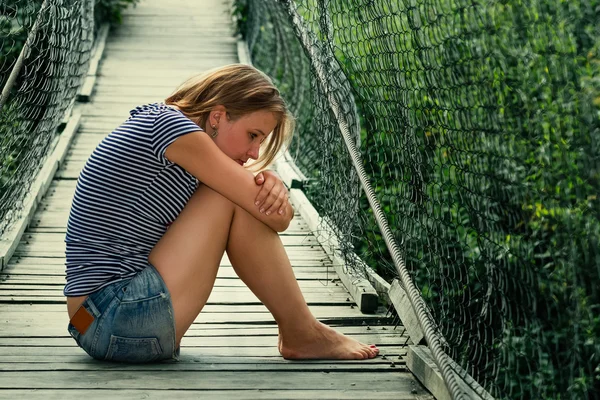 Portrait of a sad girl on the bridge — Stock Photo, Image