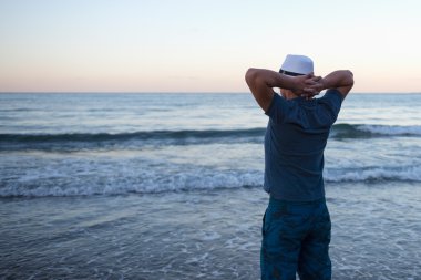 Adam günbatımında denizin üzerinde başarılı bir günün sonunda görünüyor.