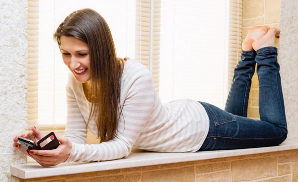 Hermosa joven con un teléfono celular en la mano —  Fotos de Stock