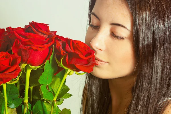 Retrato de una hermosa joven con un ramo de rosas — Foto de Stock