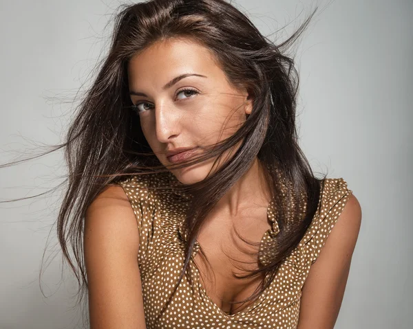 Portrait of a beautiful young woman on a gray background — Stock Photo, Image