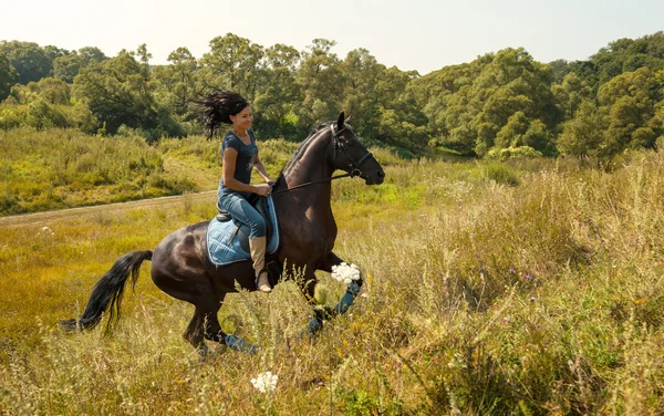 Retrato de uma bela jovem montando um cavalo. — Fotografia de Stock