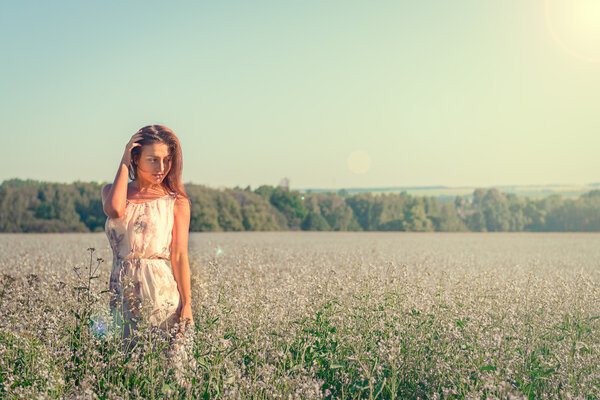 Portrait of a beautiful young woman among a field of flowers.