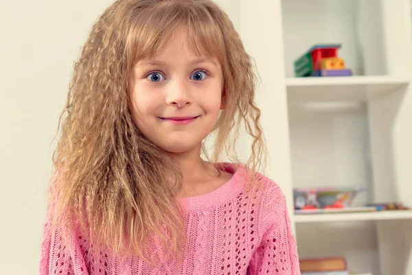 Porträt eines schönen lächelnden kleinen Mädchens im Kinderzimmer. — Stockfoto