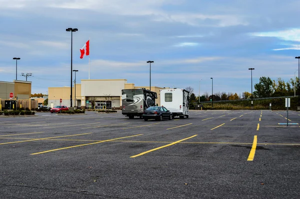 Wohnmobile Auf Leerem Mall Parkplatz Mit Kanada Flagge Vor Blauem Stockbild