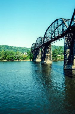 Batı Virginia 'da nehir üzerinde berrak mavi bir gökyüzünün altında demiryolu köprüsünün yan görüntüsü