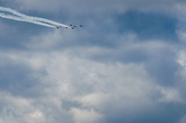 Savaş uçakları gökyüzünde fırtına bulutlarının üzerinde mevzileniyor. Arkalarında da yaz günü iki jet yolu var..