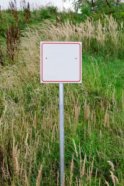 Square blank sign against green grass