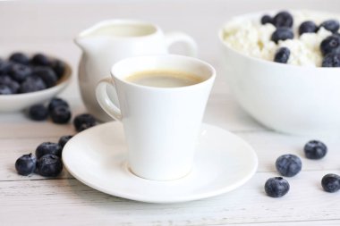 Bir fincan kahve ve yabanmersinli ev yapımı süzme peynir, sağlıklı bir kahvaltı.