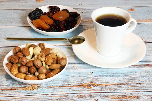 nuts, dried fruits and a cup of coffee on the table, healthy food