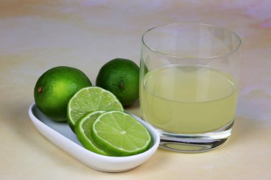 Bir bardak limon suyu ve taze limon dilimleri. 