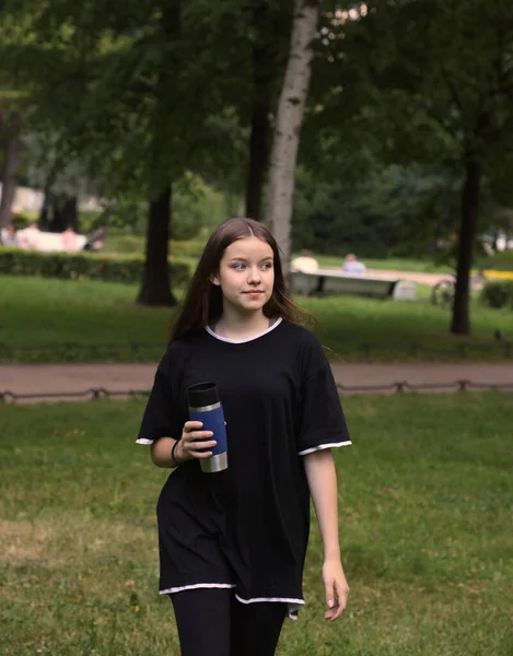 屋外の公園で水やスポーツドリンクを飲み健康的なライフスタイルを持つ若いスポーツの女の子 — ストック写真