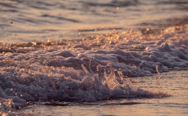 Dalgalar deniz kıyısı makrosu sıçratıyor. Yaklaş.