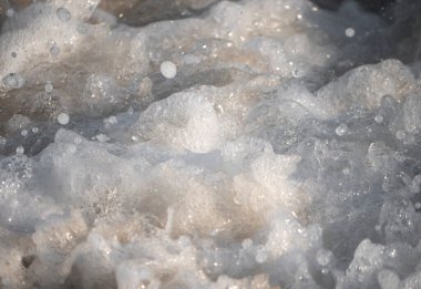 Dalgalar deniz kıyısı makrosu sıçratıyor. Yaklaş.