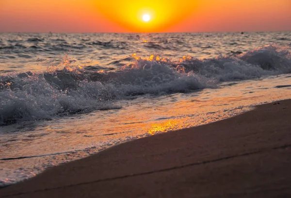Denizin ve kumsalın üzerinde gün doğumu