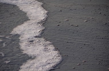 Dalgalar deniz kıyısı makrosu sıçratıyor. Yaklaş.