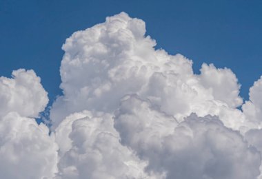 Gökyüzü manzarasına karşı beyaz kabarık büyük bulutlar