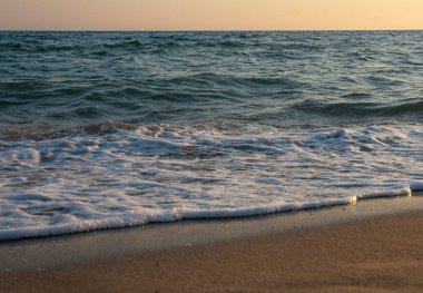Dalgalar deniz kıyısı makrosu sıçratıyor. Yaklaş.