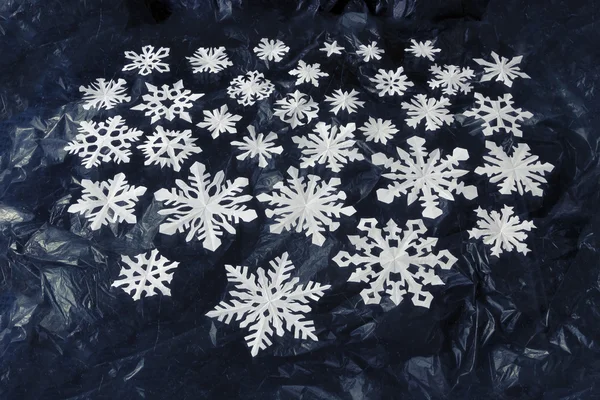 Copos de nieve de papel blanco sobre fondo azul oscuro — Foto de Stock