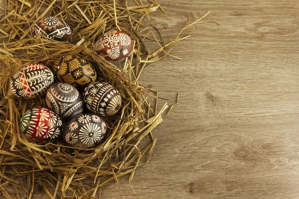 Tahta arka planda yuvada paskalya yumurtaları
