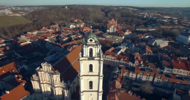 AERIAL. Полет по плавной орбите вокруг церкви Св. Иоанна (Св. Jonu baznycia) в Вильнюсе. Красивый вид на старый город столицы Литвы. 4K — стоковое видео