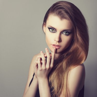 Güzel seksi genç bir kadın ile mükemmel cilt ve makyaj closeup portresi. Duygusal fotoğraf Studio. El dudaklar yakınındaki