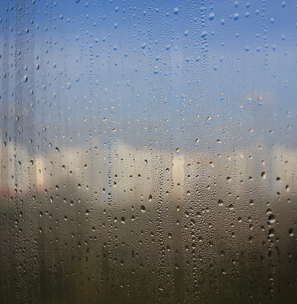 Gotas de água naturais no vidro da janela com fundo da natureza — Fotografia de Stock