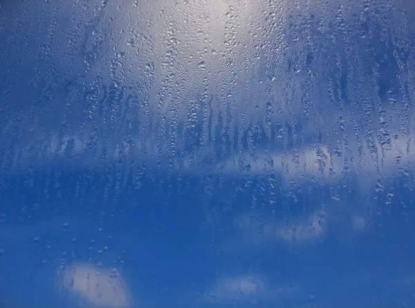 Gotas de água naturais em vidro de janela com fundo do céu — Fotografia de Stock