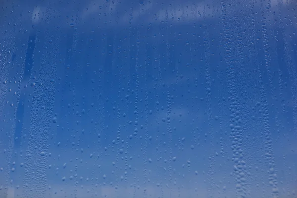 Natural water drops on window glass with sky's background — Stock Photo, Image