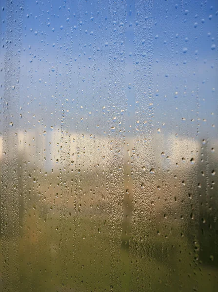 Doğal su damlaları doğanın arka planında pencere camına düşer. — Stok fotoğraf