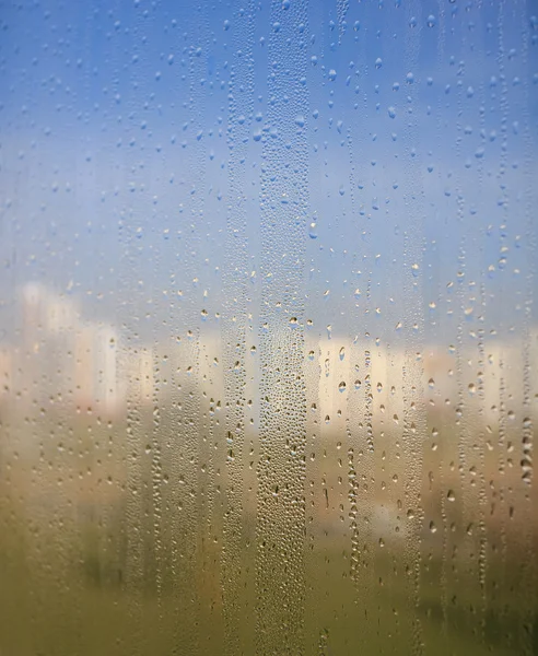 Natürliche Wassertropfen auf Fensterglas mit Naturhintergrund — Stockfoto