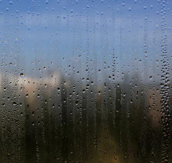 Gotas de água naturais no vidro da janela com fundo da natureza — Fotografia de Stock