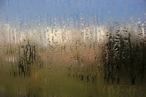 Gotas de agua natural en vidrio de ventana con fondo natural — Foto de Stock