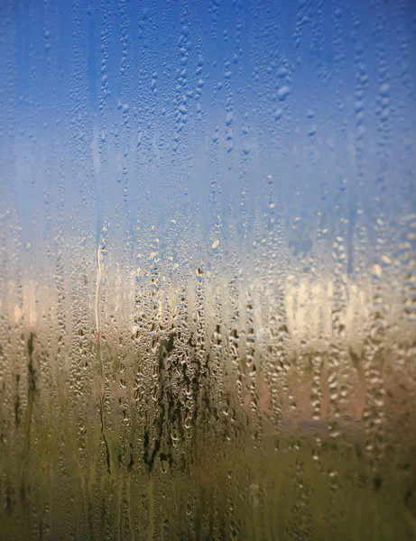 Gocce d'acqua naturali sul vetro della finestra con sfondo naturale — Foto Stock