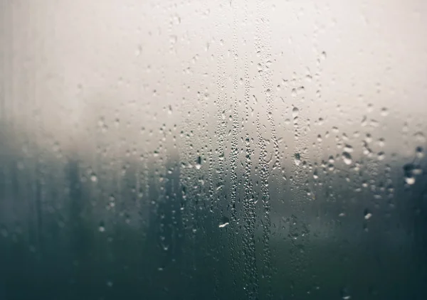 Gotas de agua natural en vidrio de ventana con fondo natural — Foto de Stock