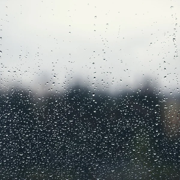 Gotas de água naturais no vidro da janela com fundo da natureza — Fotografia de Stock