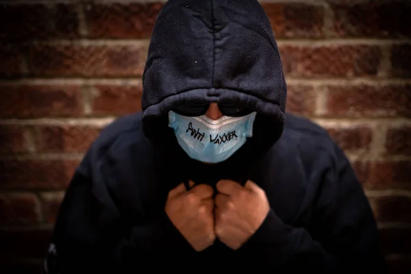 Een Persoon Met Een Gezichtsmasker Met Opschrift Vaxxer Hoodie Zonnebril Rechtenvrije Stockfoto's