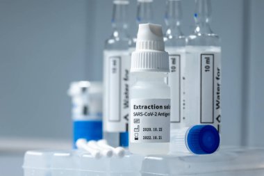 Sars-CoV-2 Antijen Rapid testi Covid-19 arka planda çeşitli tıbbi malzemelerle