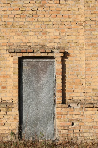 Porta velha cravejado de metal em um edifício de tijolos — Fotografia de Stock