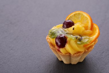 meyveli kek kiraz, kivi ve turuncu gri bir arka plan üzerinde 