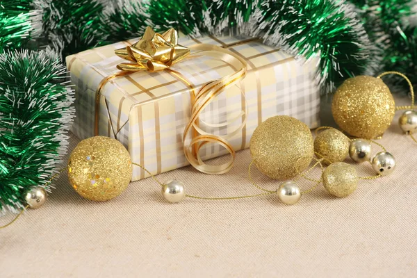 Geschenk, goldene Kugeln auf dem Hintergrund Tuch — Stockfoto